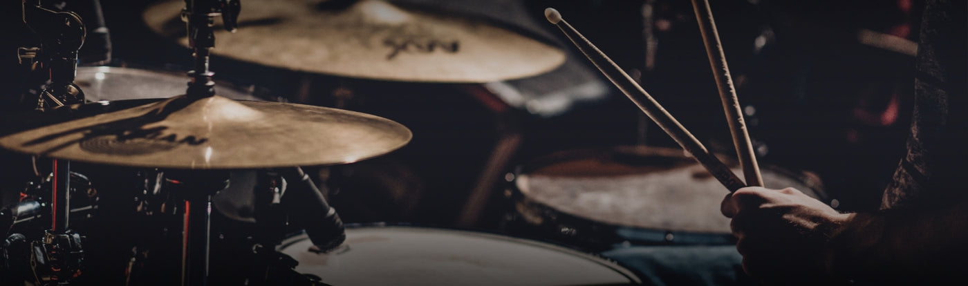 Close-up of a person playing drums with drumsticks